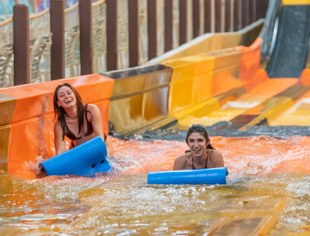 two women with waterpark mats on a slide