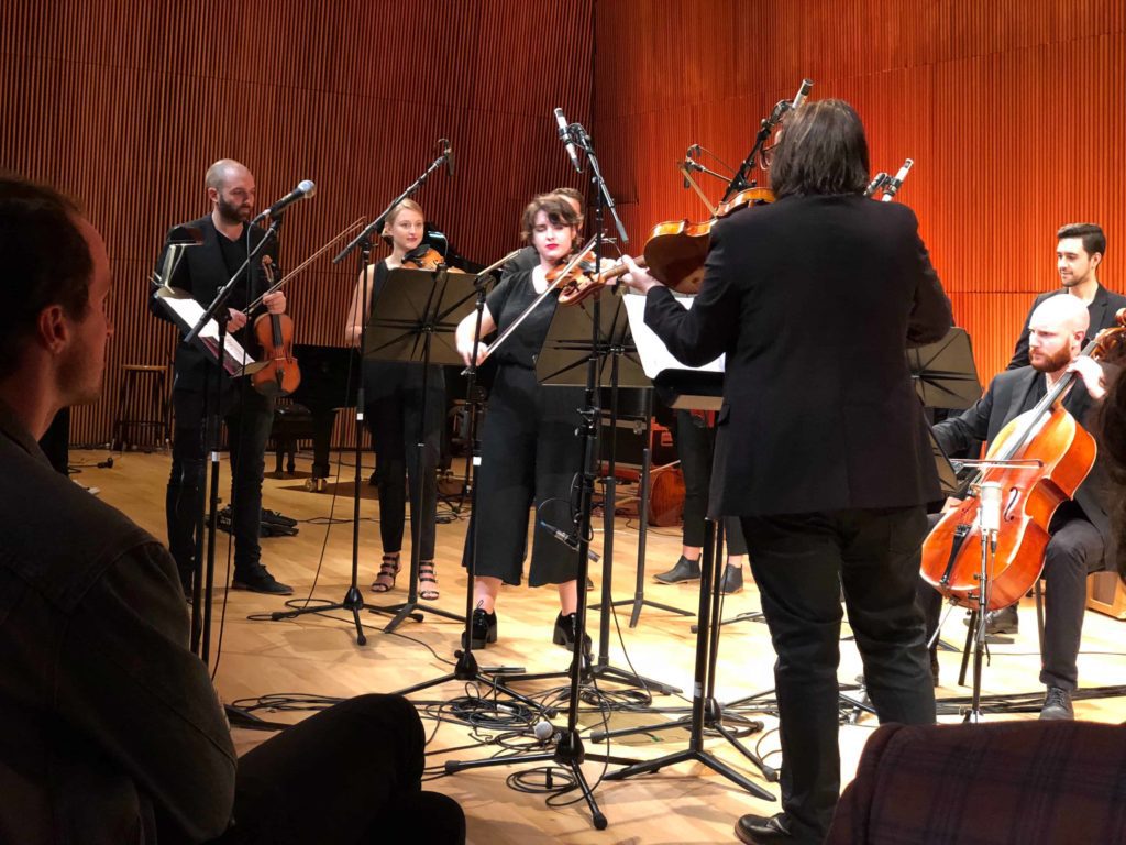 People dressed in black playing violins and stuff