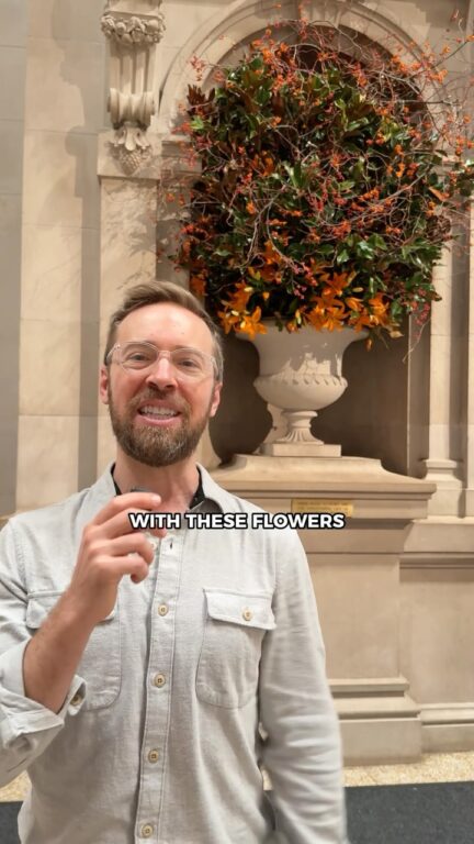 Man talking with flowers in the background