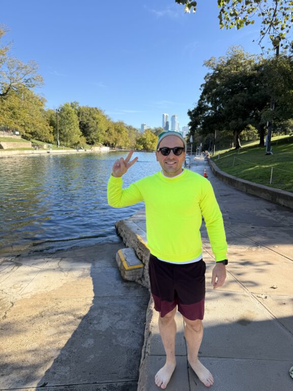 Man wearing a neon sweatshirt and shades