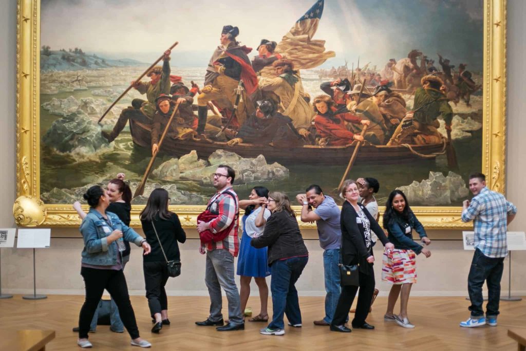 Group of people having fun at the Met Museum in front of Washington Crossing the Delaware painting