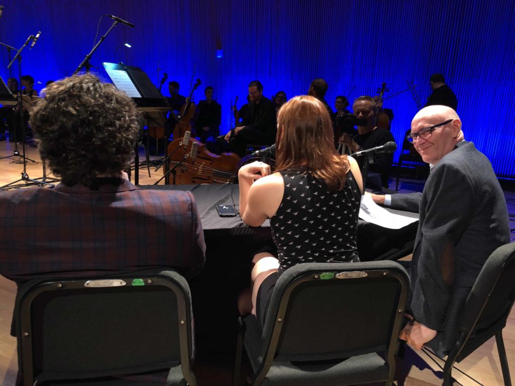 Three people sitting at a table, backs to us
