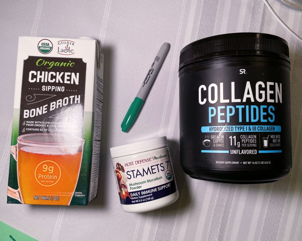 Overhead photo of a box containing bone broth, plus mushroom powder and Collagen Peptides