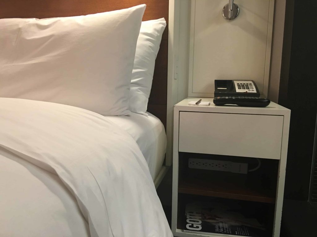 Bed closeup, and night stand. Do you see that nice power strip??