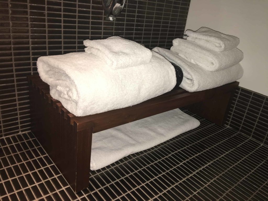 Towels underneath the sink. I like the wood rack.