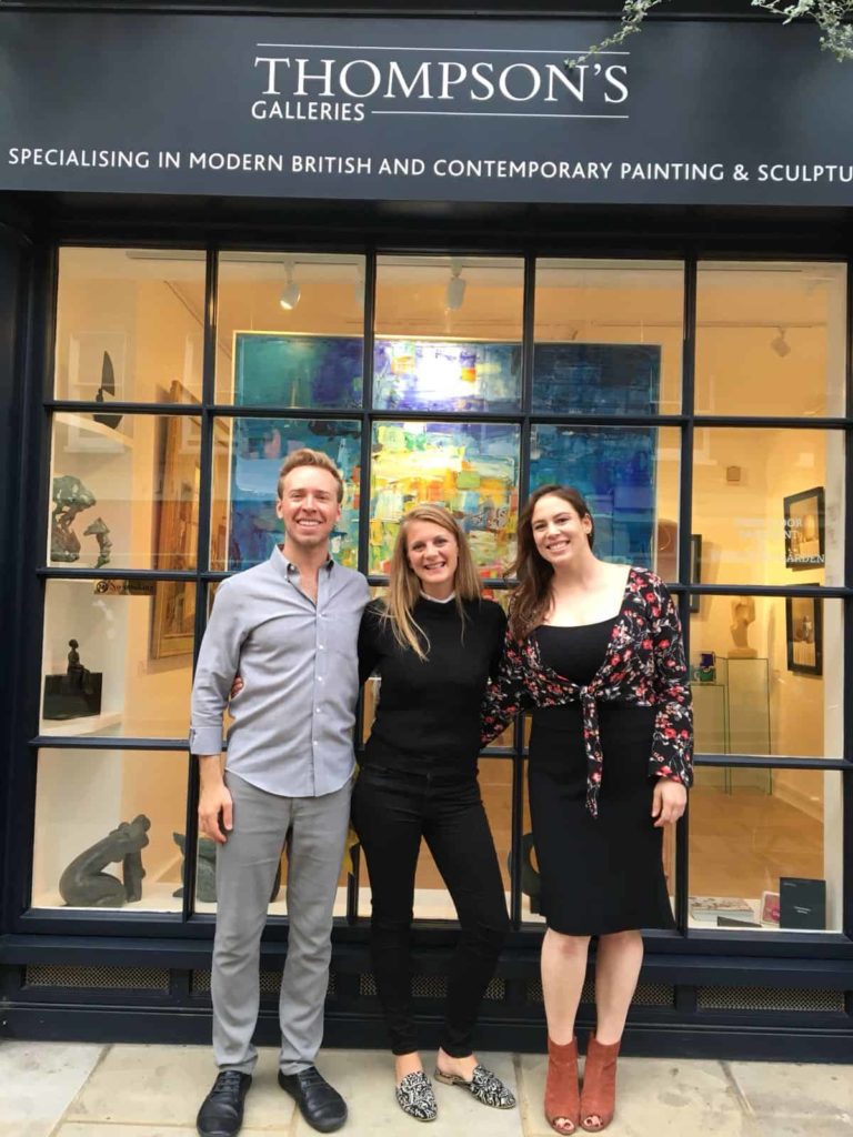 Three people in front of an art gallery