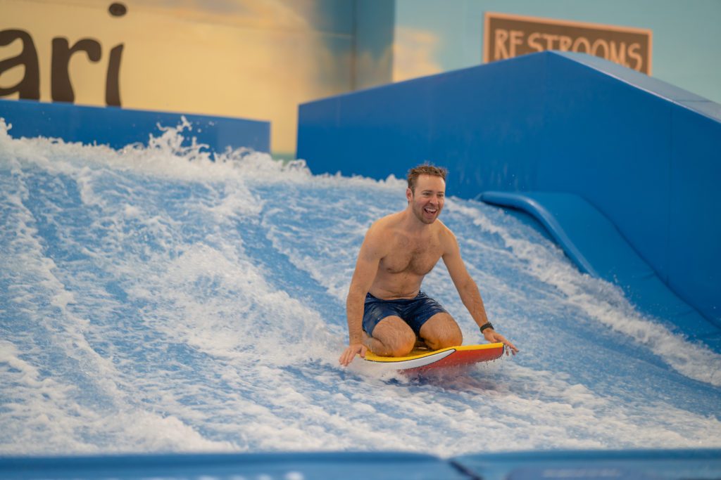 man on his knees on Flowrider boogie board