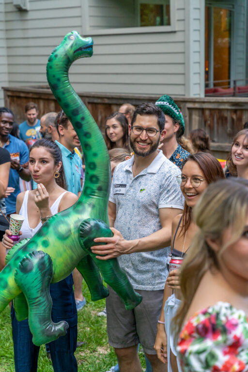 A man named David Shapiro holding an inflatable brontosaurus dinosaur