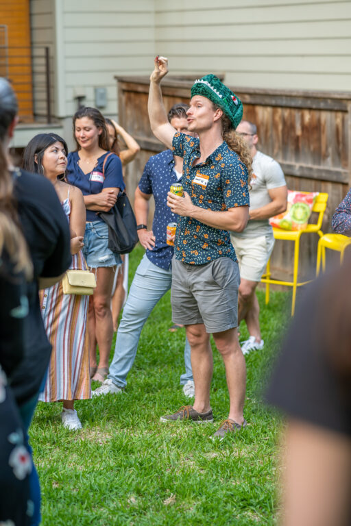 Man with long hair wearing a dinosaur hat