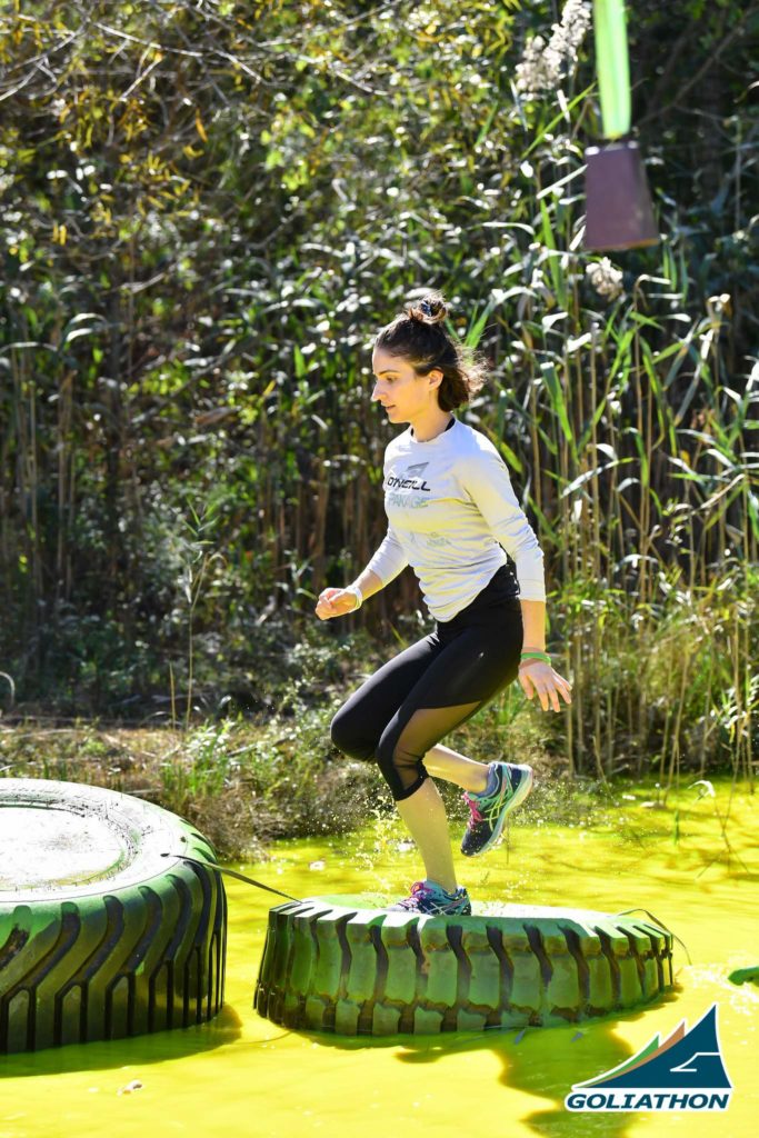 Woman stepping on tire in green liquid water