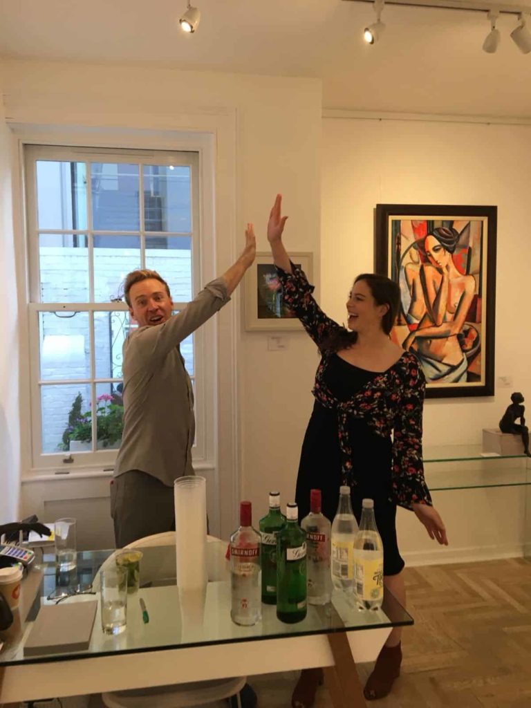 Two people doing a hi-five inside an art gallery