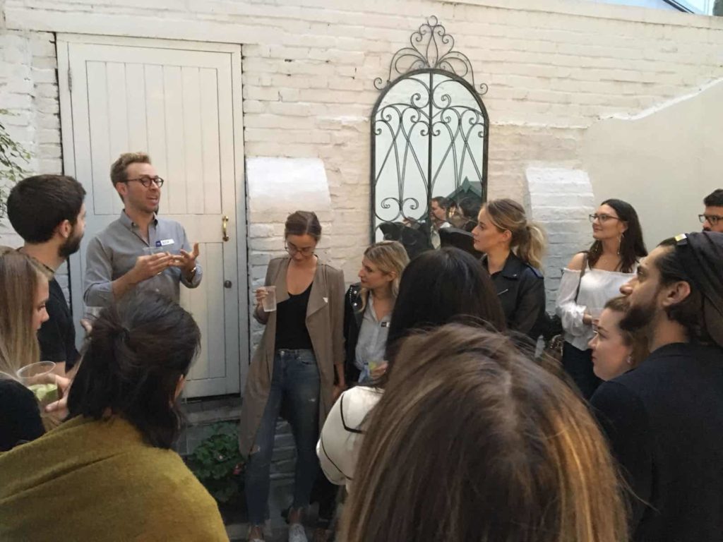 People outside against a white wall