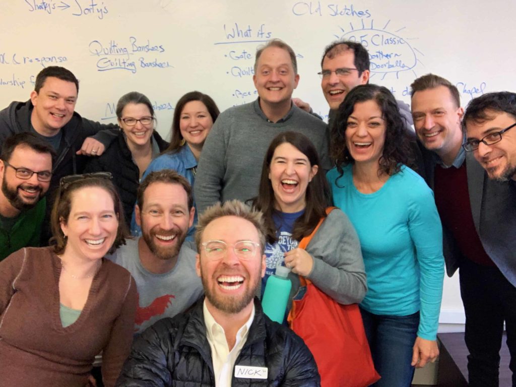 Group of very happy Lilting Banshees alumni inside a classroom all smiling