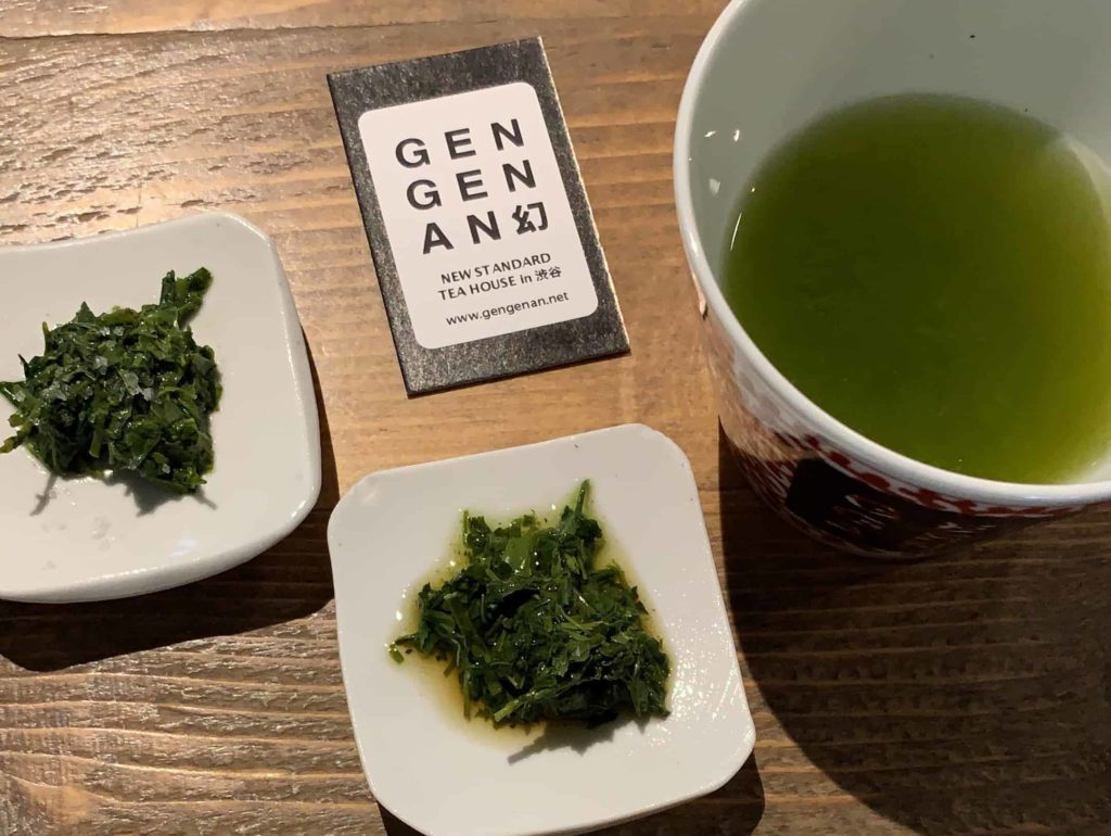Two small places with clumps of tea that looks like wet grass, plus a bowl with green tea on the right side