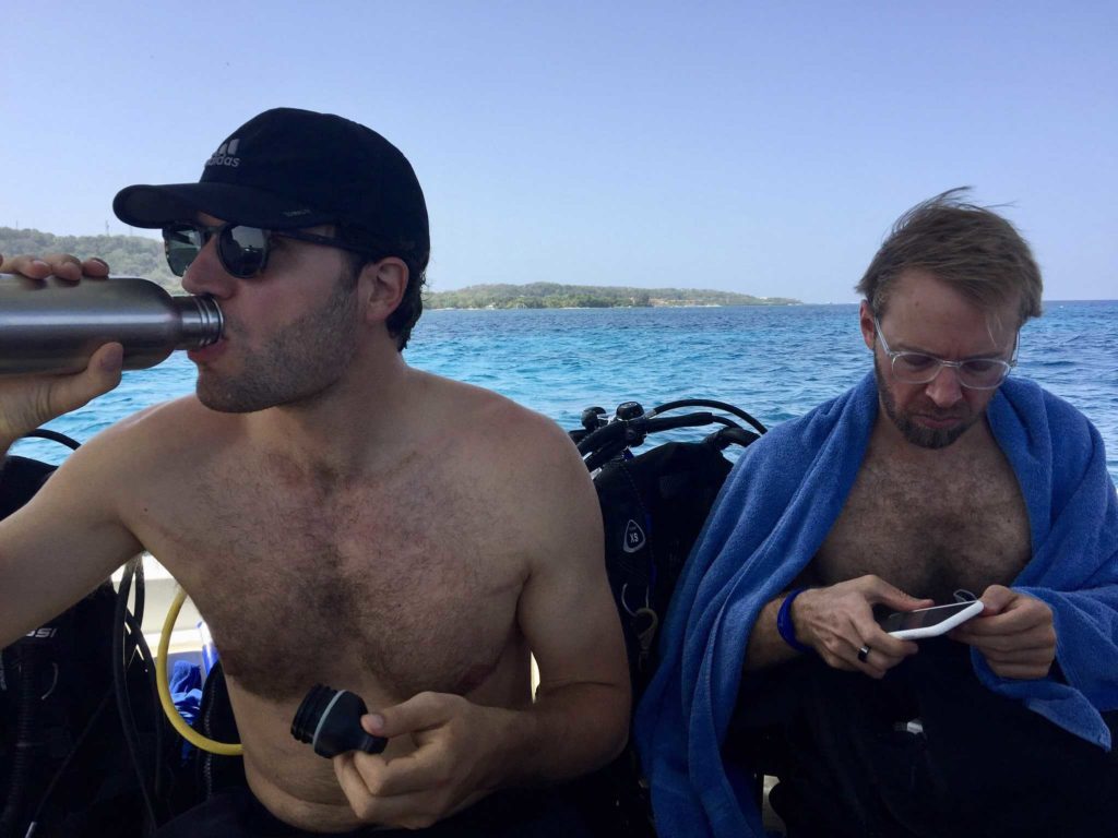 Man drinking water, me on my phone with towel on my shoulders