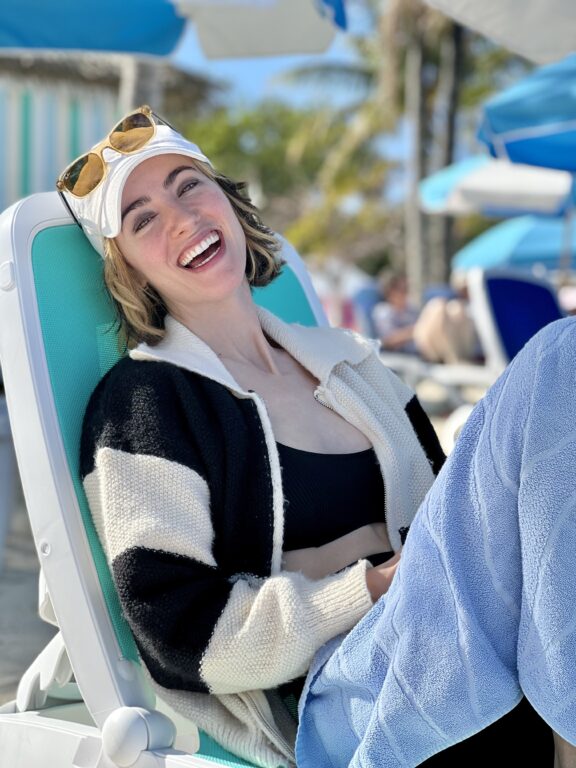 woman wearing hat and sunglasses in a beach chair