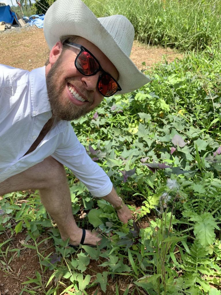 Man wearing sunglasses and cowboy hat on a farm