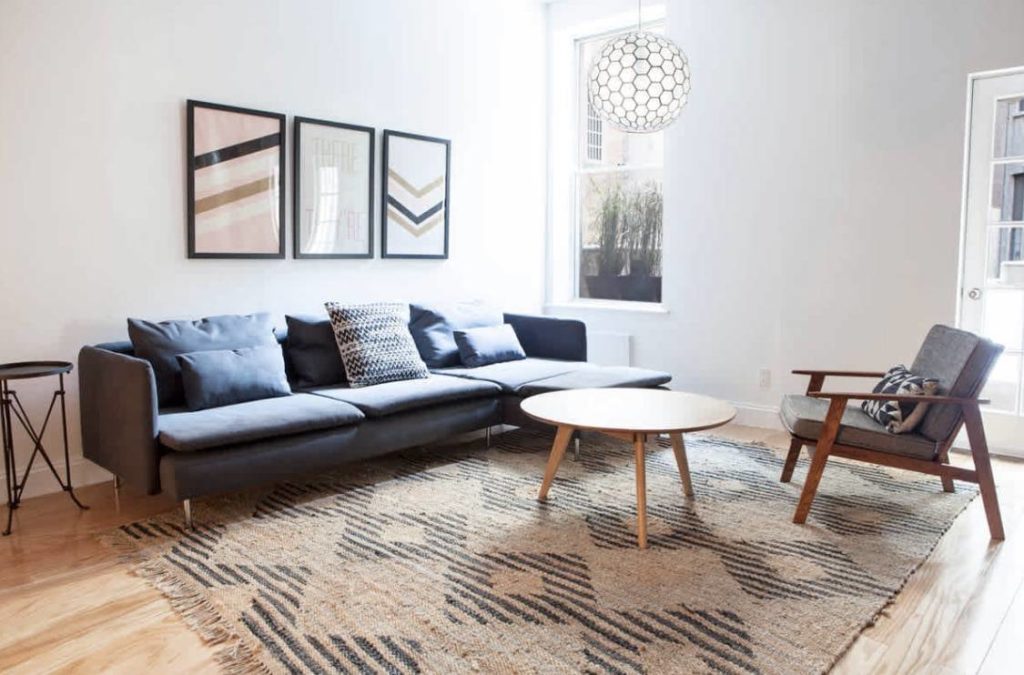 Blue sofa and rug underneath with table and chair nearby