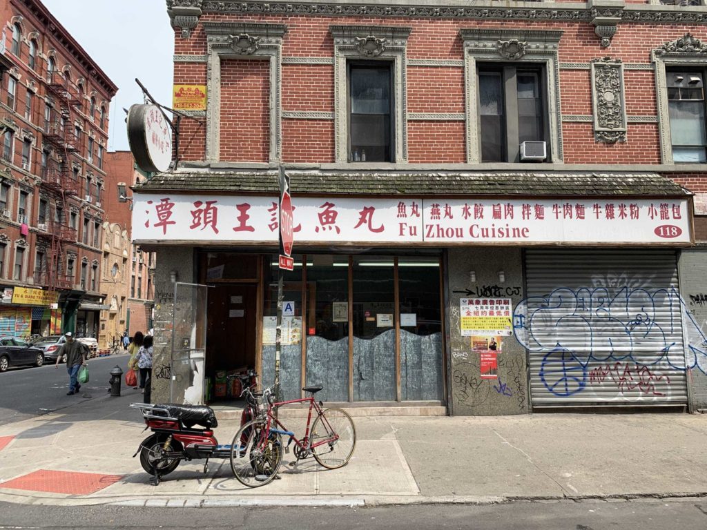 New York City street corner. Shows a building with Chinese characters