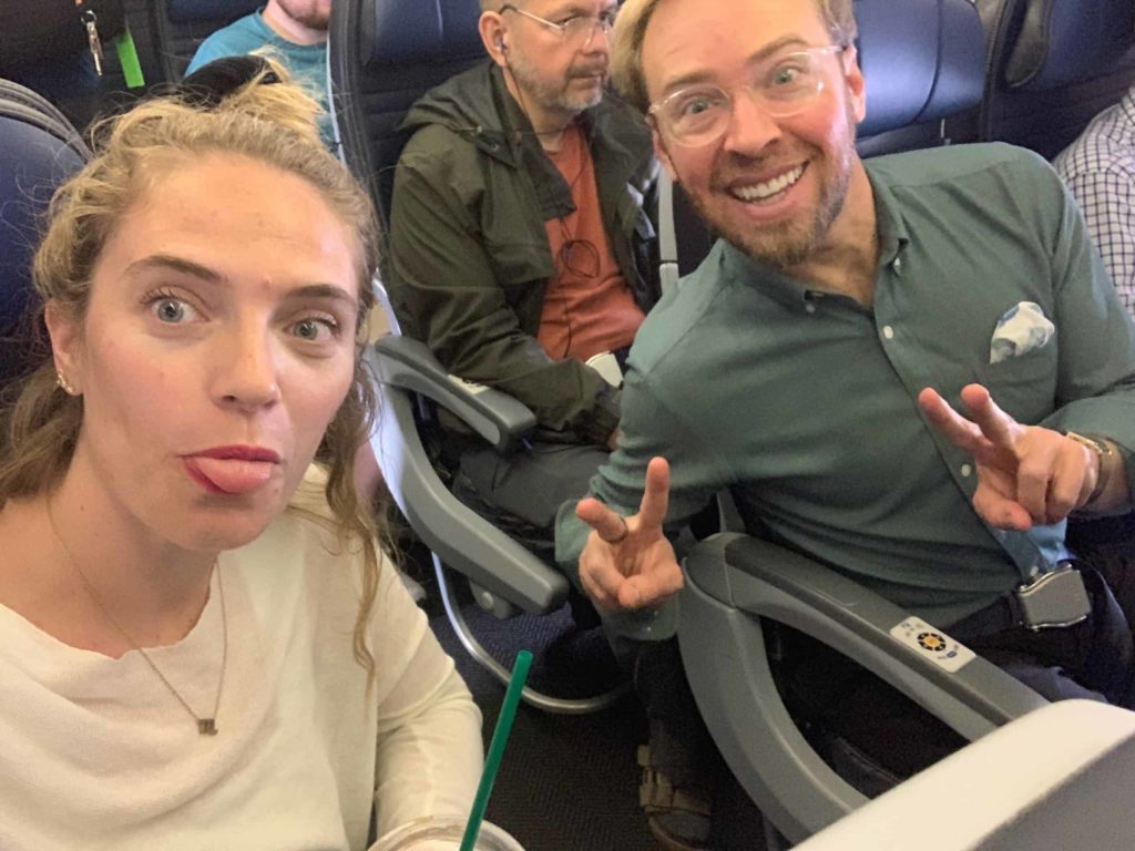 Two attractive blondes sitting on a flight