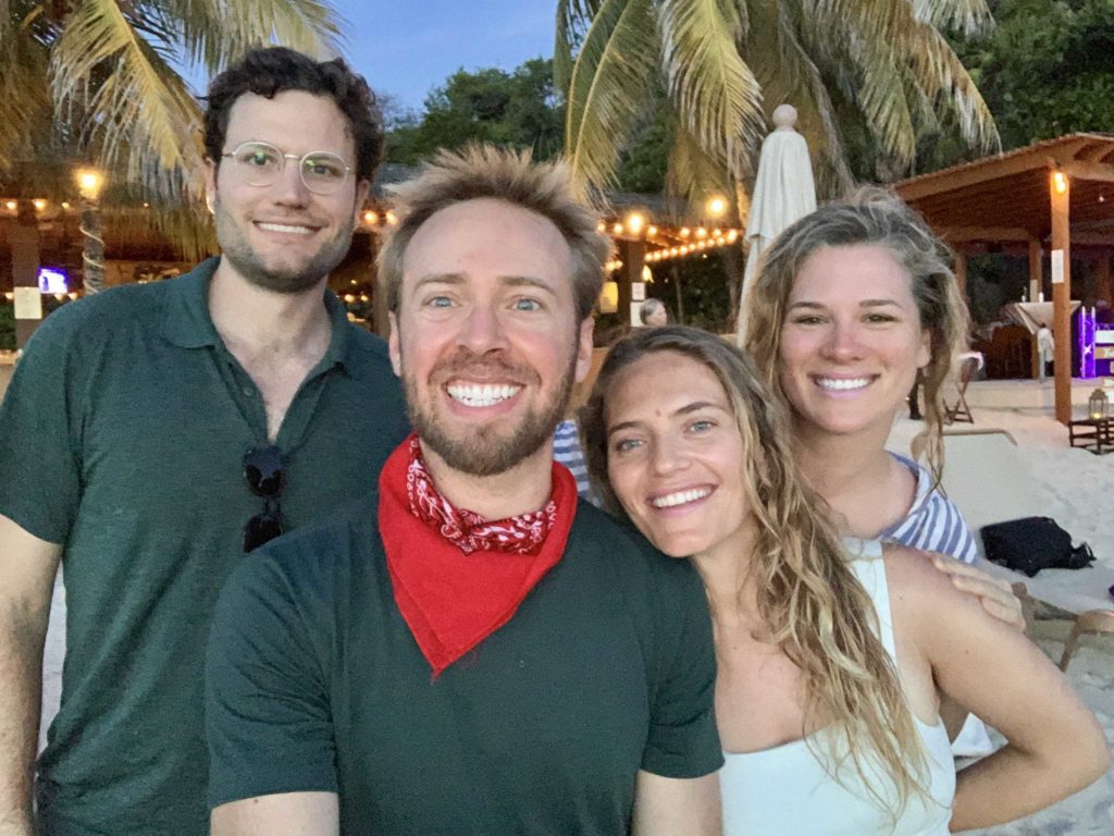 Four people in selfie mode on the beach in Roatan