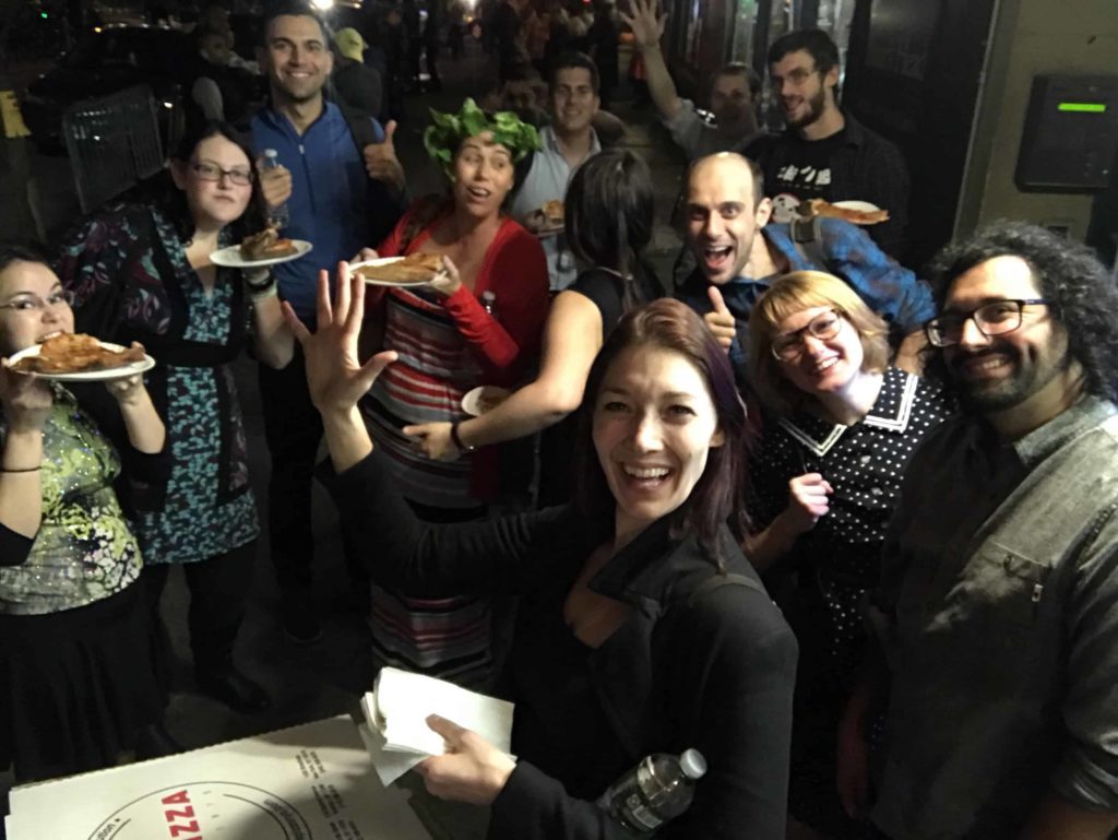 Group of our team during a team building retreat eating pizza outside on the streets of NYC