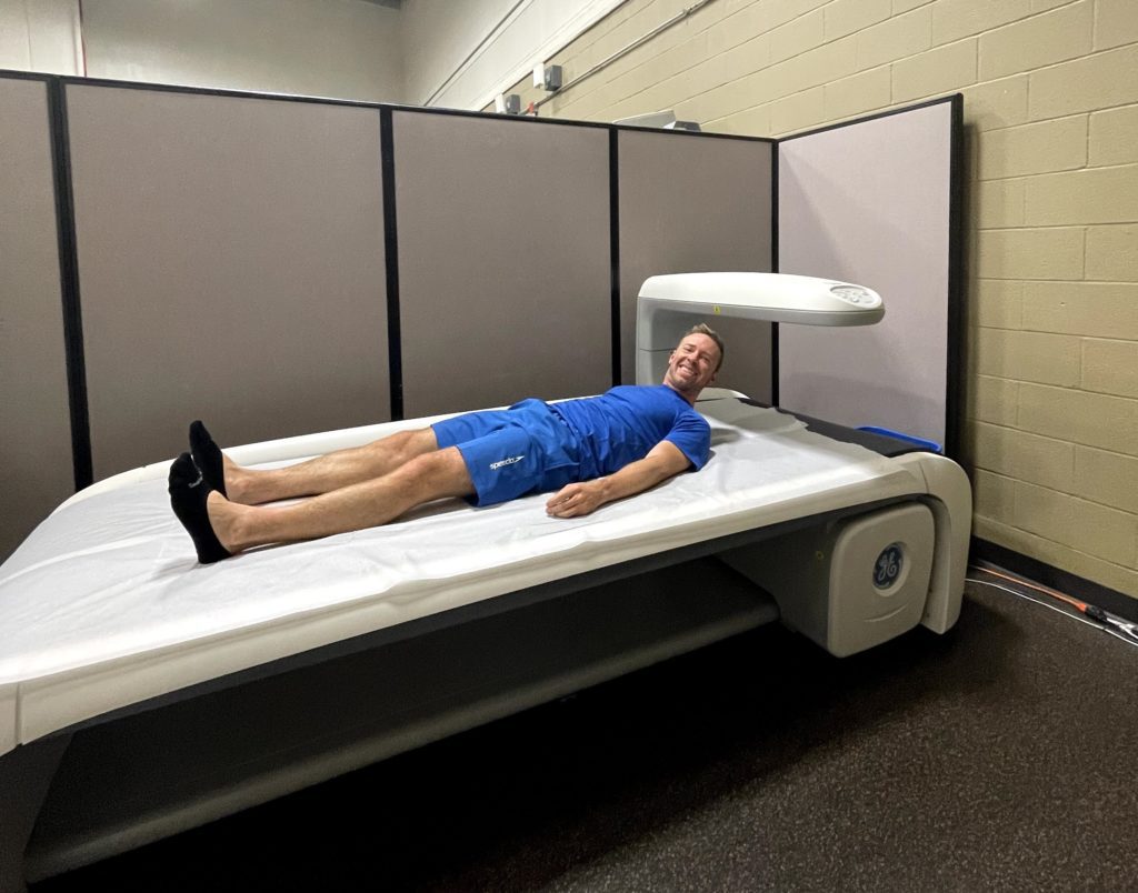 me wearing blue laying on a GE DXA machine at UT Austin campus