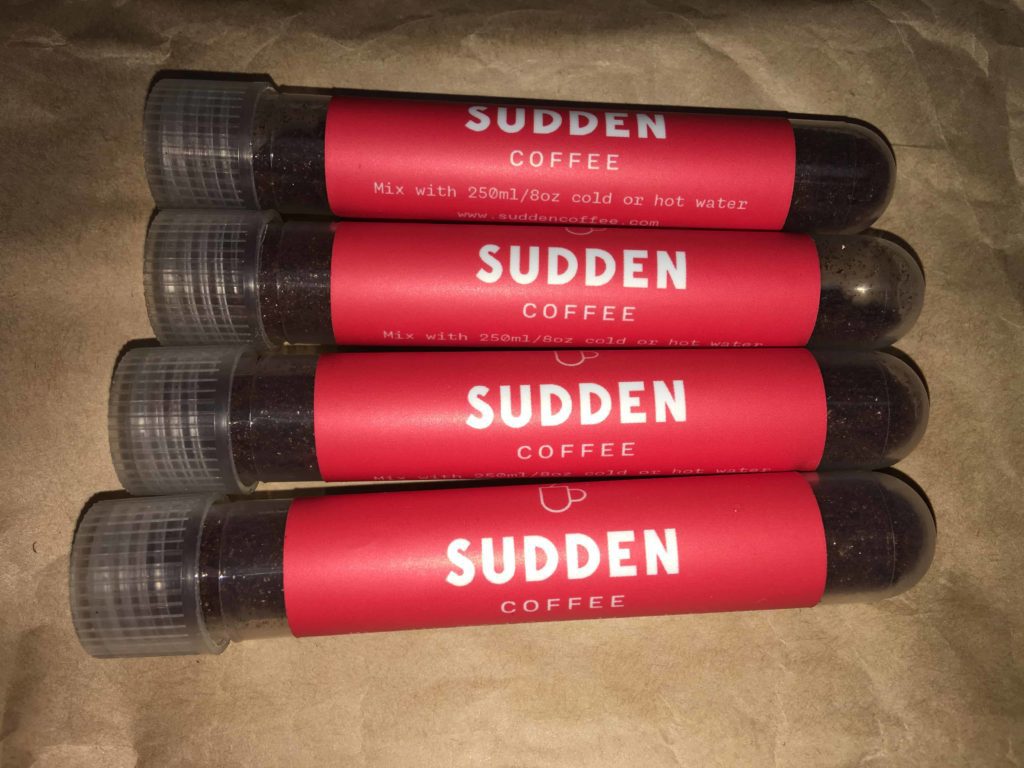 Four tubes of Sudden Coffee, plastic container with sticker