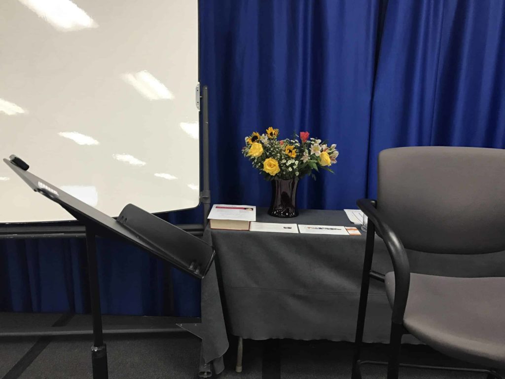 Closeup of a conference stage setting with flowers on a black table