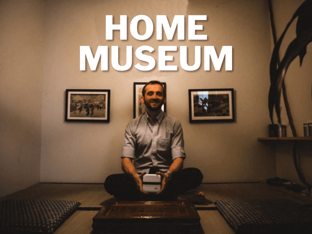 Header text: Home Museum, a photo of a guy holding a box while sitting
