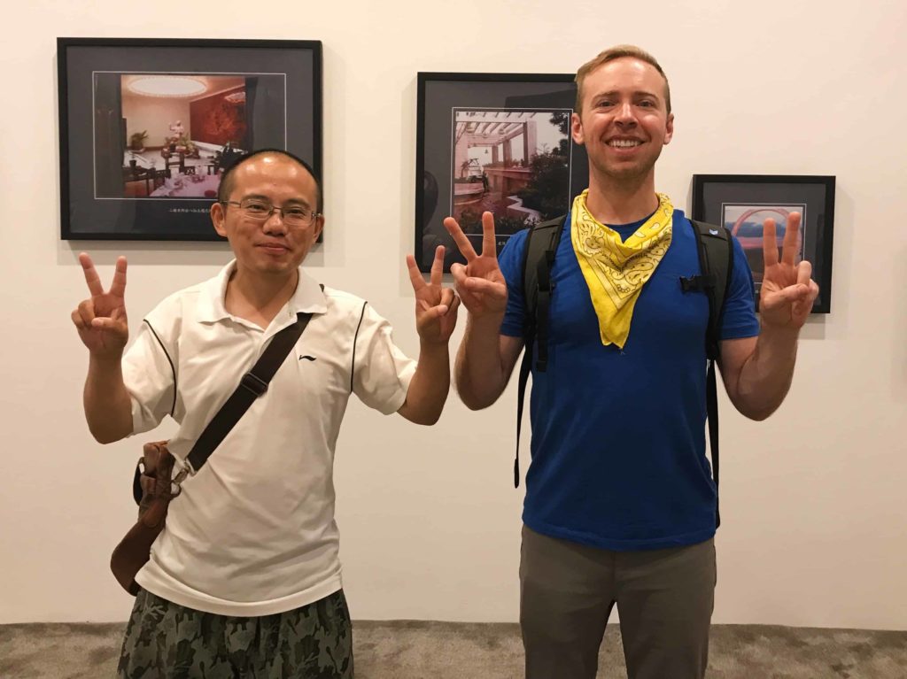 two people, standing with the PEACE signs