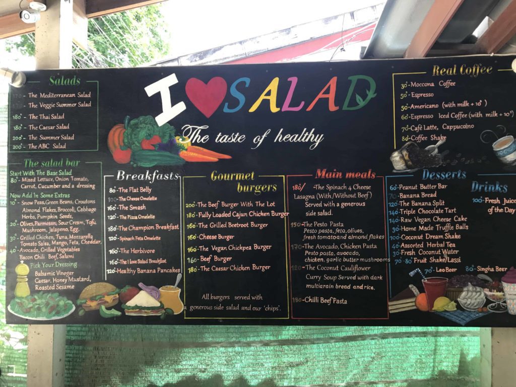 Black signboard with I Love Salad logo and lots of items for sale