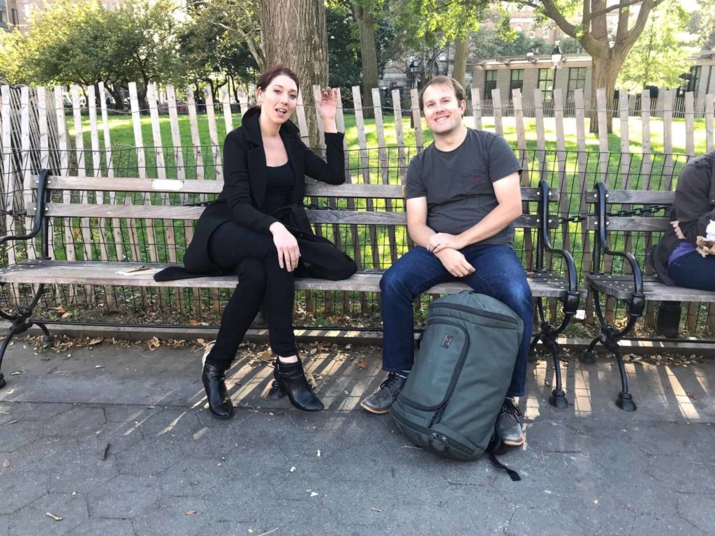 Two people sitting on a bench in NYC's Washington Square Park