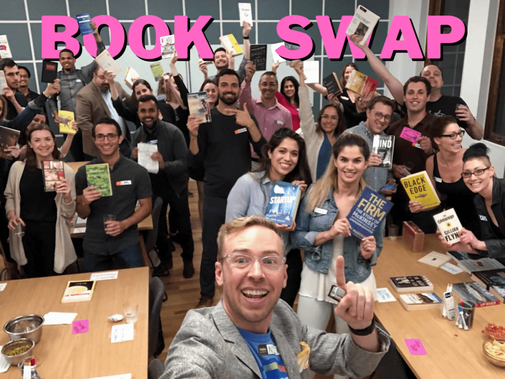 Group of people holding a book with the title book swap on top