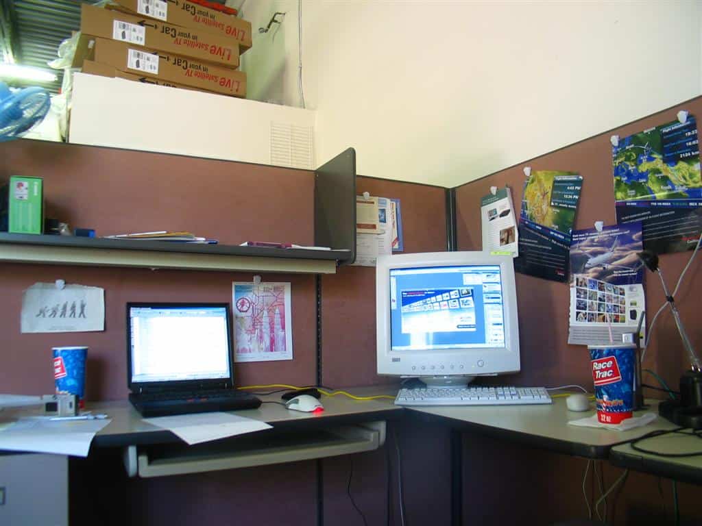 Desktop office cube with laptop and computer screen