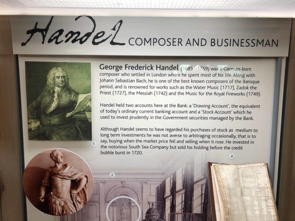 Lots of text on a white background museum exhibit and photos about Handel the classical music composer at the Bank of England