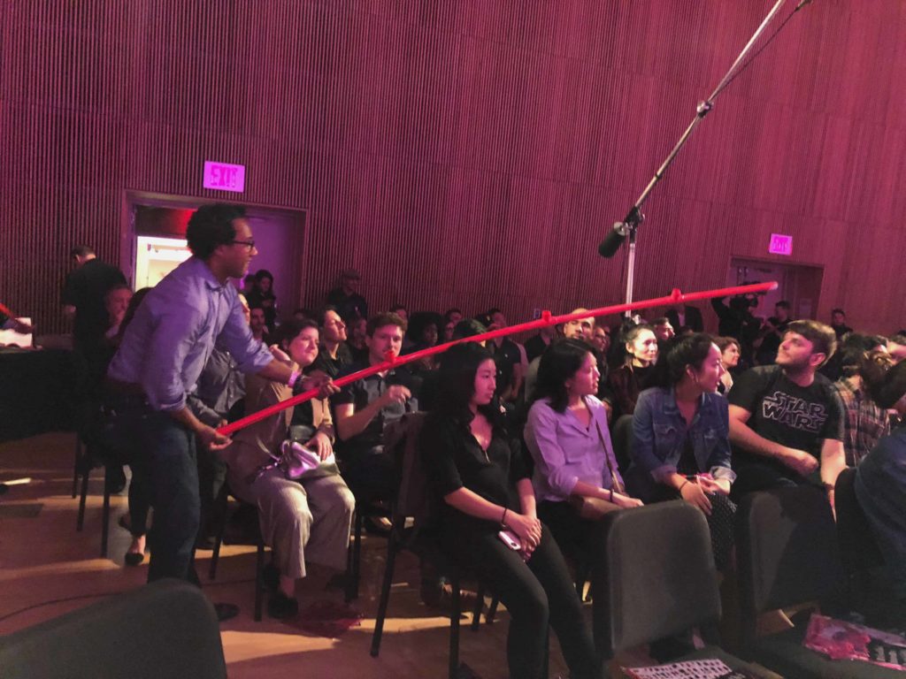 Person holding a red pole in an audience