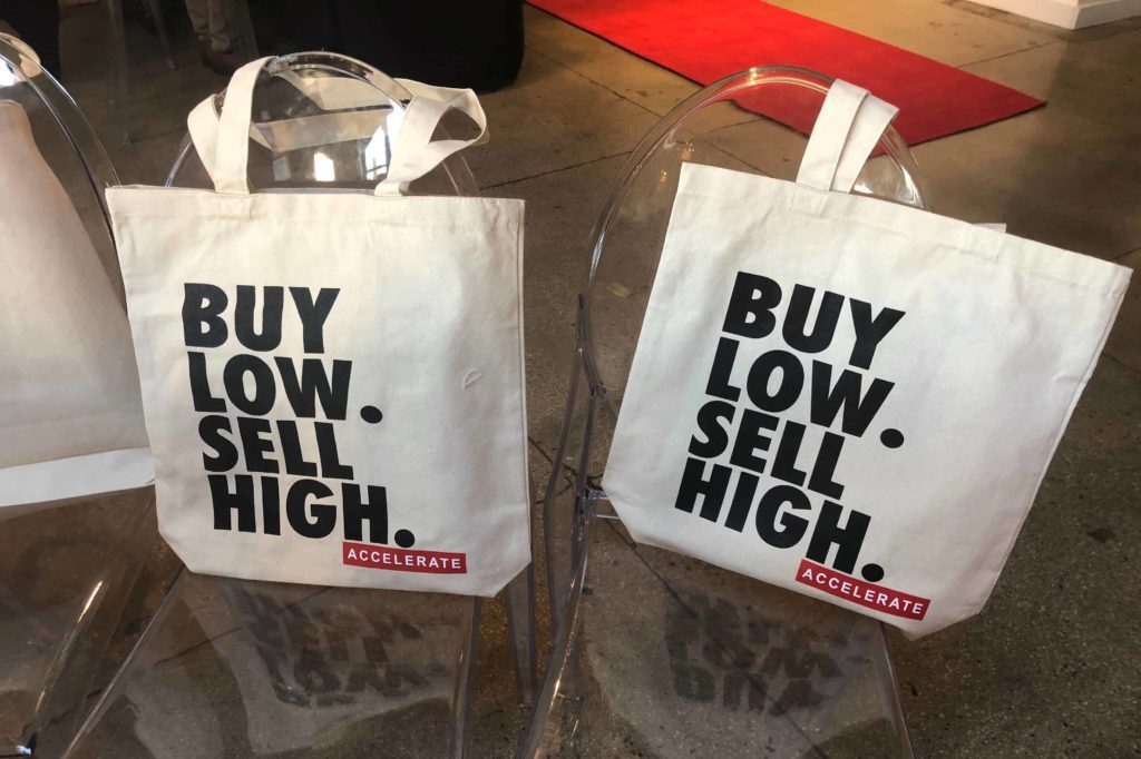 White bags that say Buy Low, Sell High