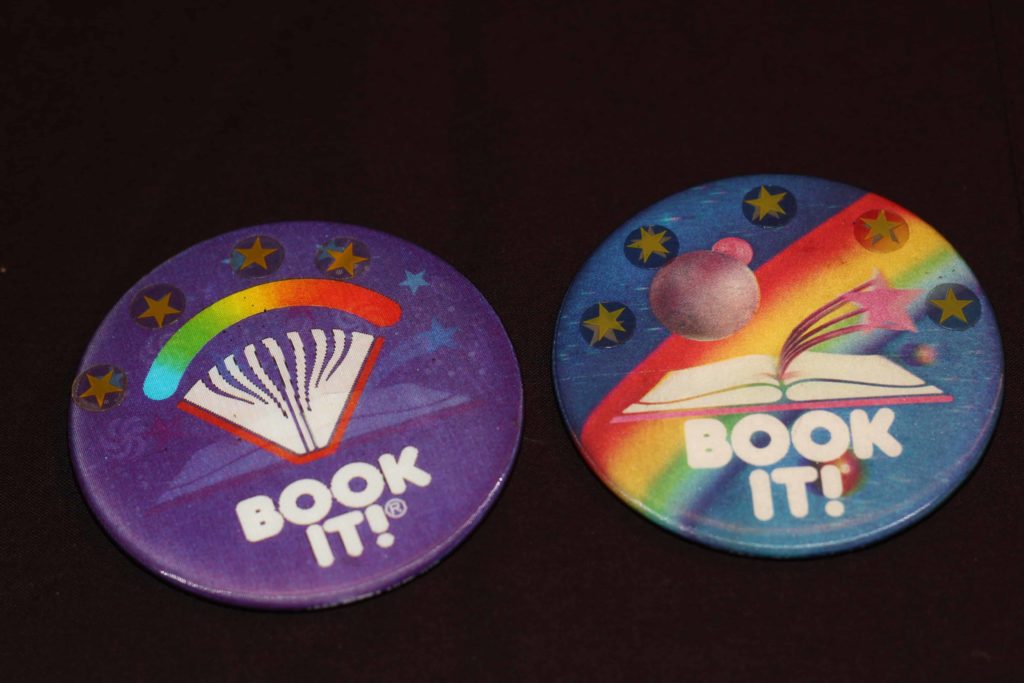 Buttons from Book It!, two circular buttons each saying Book It! on them