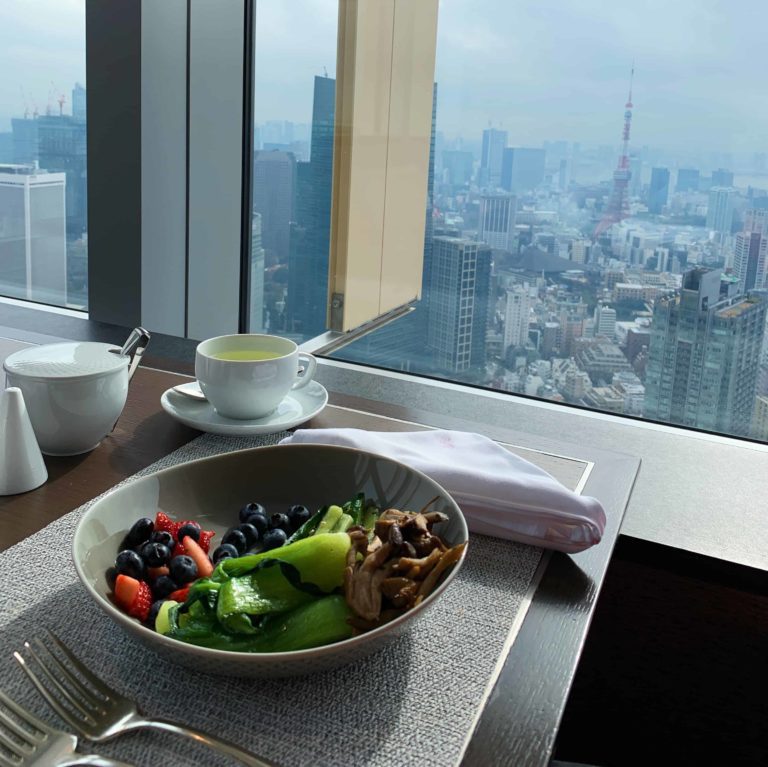 Bowl with fruit in it, overlooking downtown Tokyo outside the window