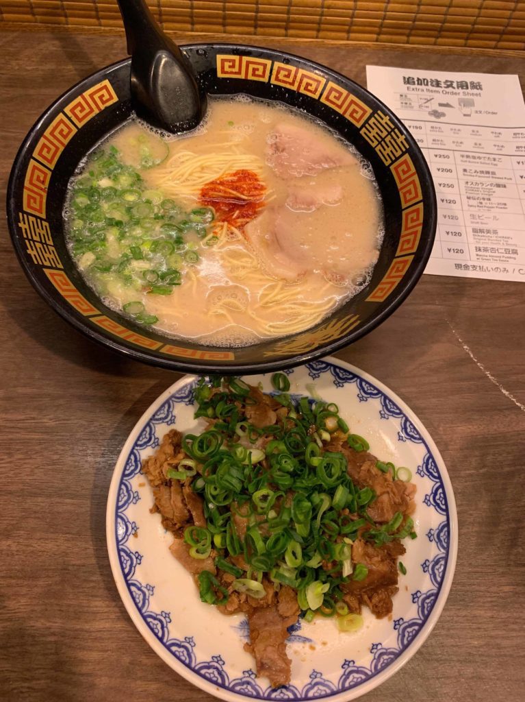 Bowl of noodles at top, plate of pork on the bottom
