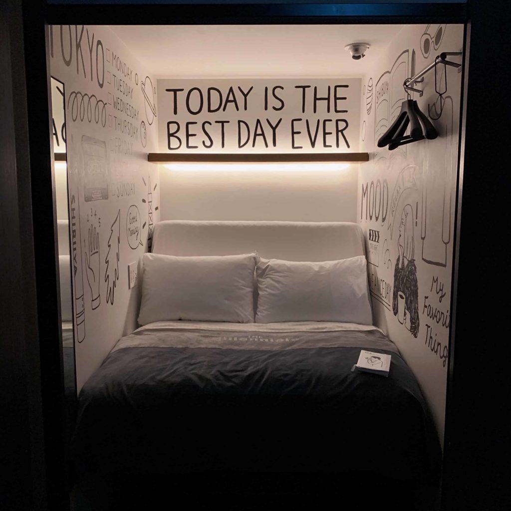 Capsule hotel at The Millennials Shibuya with quote "Today Is the Best Day Ever" above it