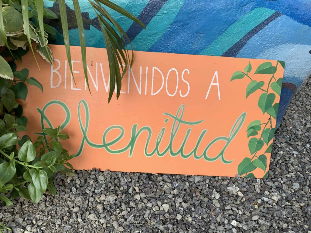 a hand-painted sign which reads: Bienvenidos a Plenitud