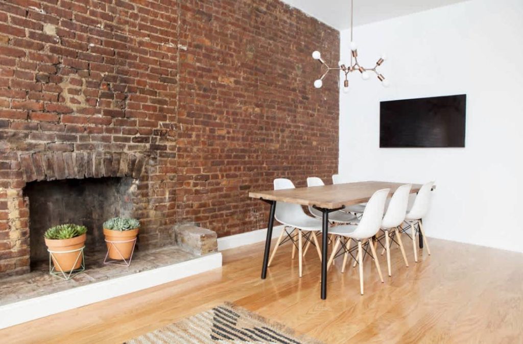 Brick wall inside an office with table and chairs