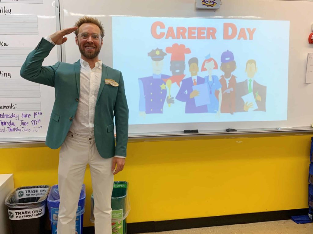 Man standing in front of sign that says Career Day inside a classroom