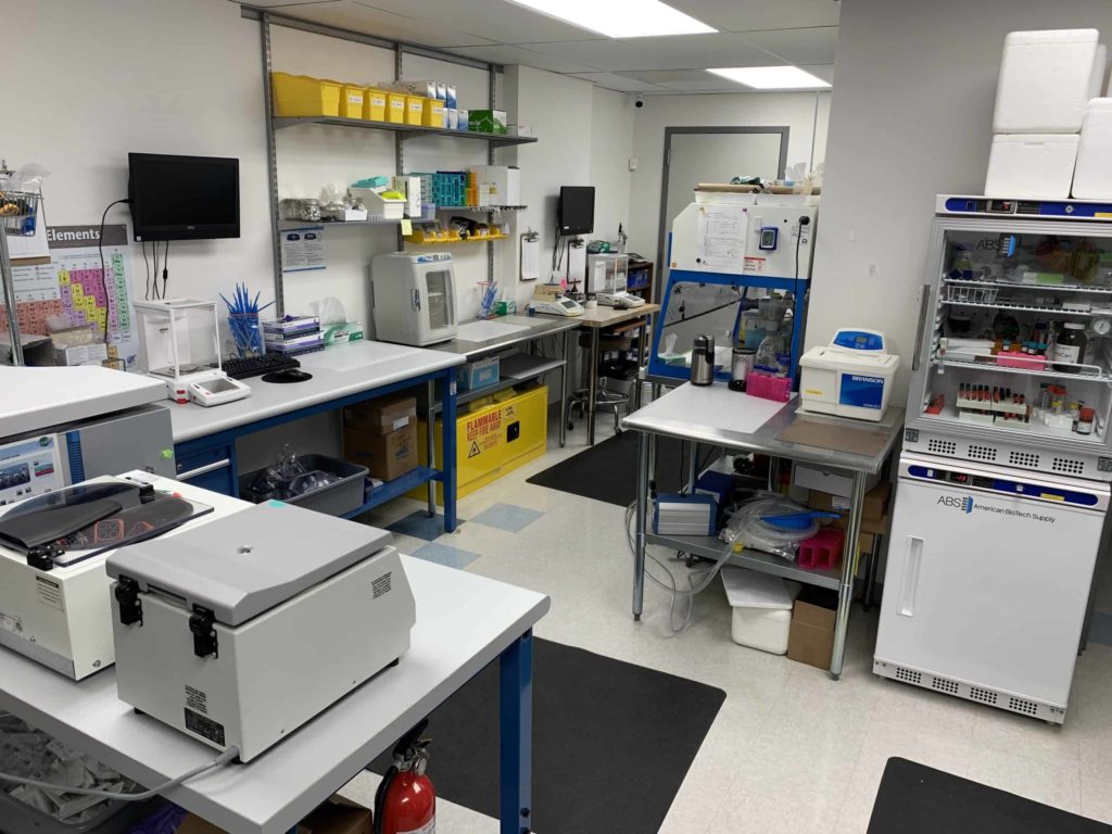 Science room, with white floors, and lots of white equipment on shelves 