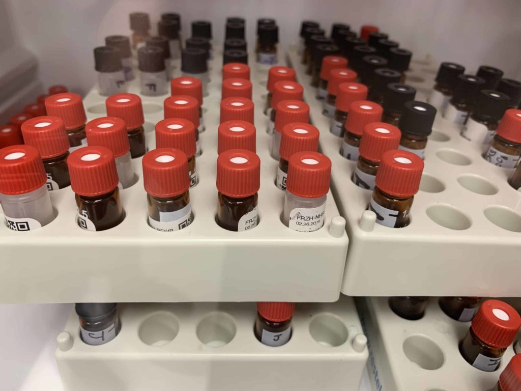 Beige trays and small vials about 2 inches tall with red caps