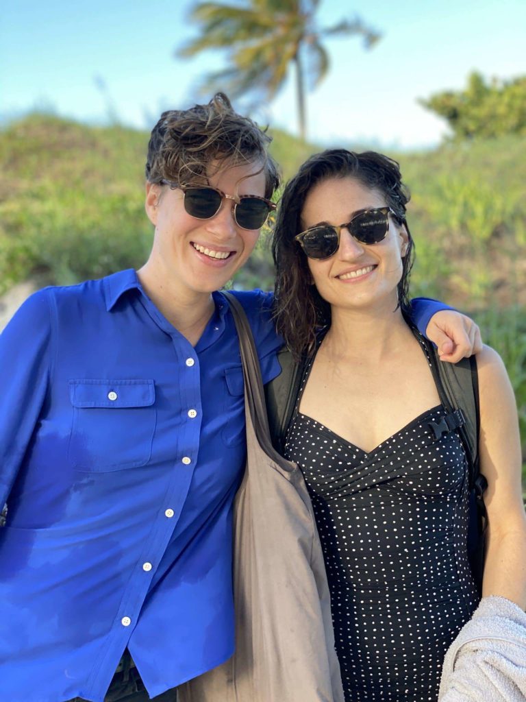 Two women wearing sunglasses and smiling