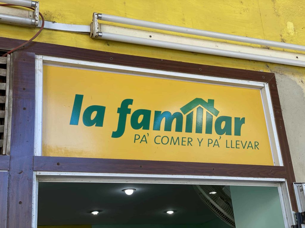 Yellow sign with green text that says “la familiar” pa comer y pa llevar