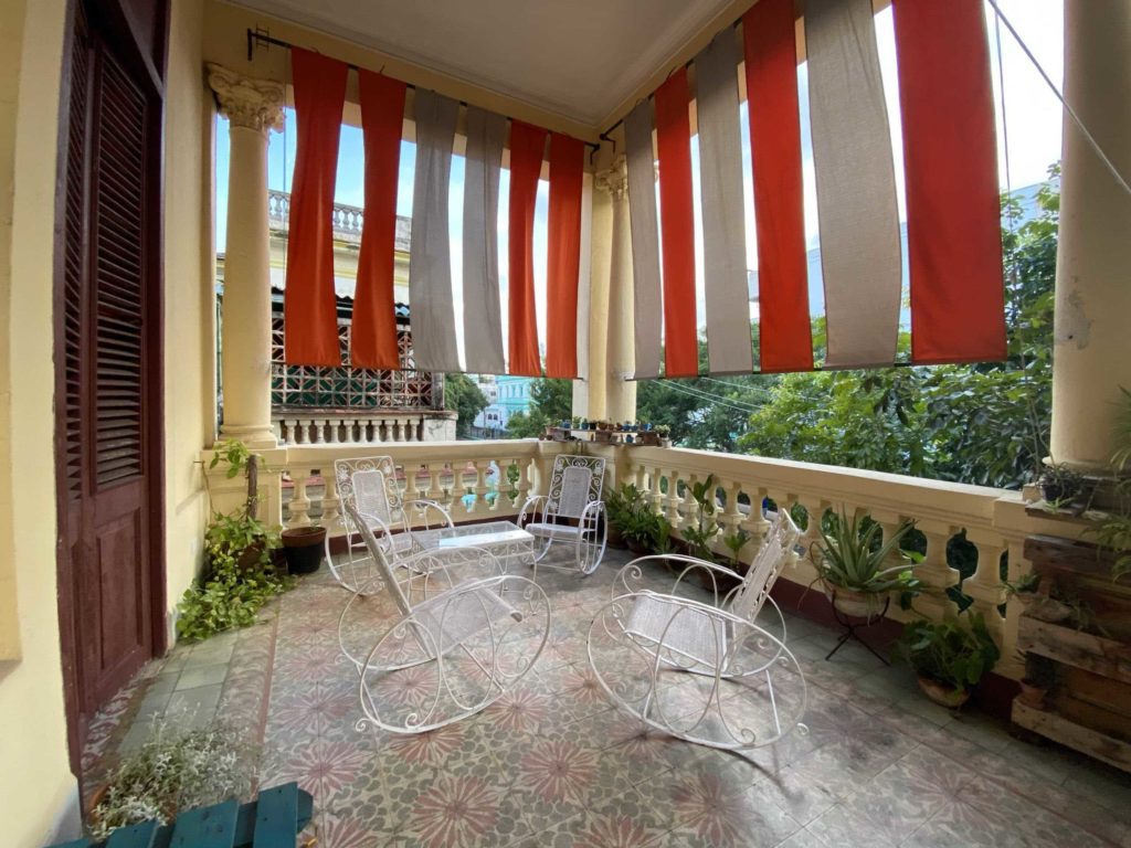 Outside pic with chairs on a balcony and columns